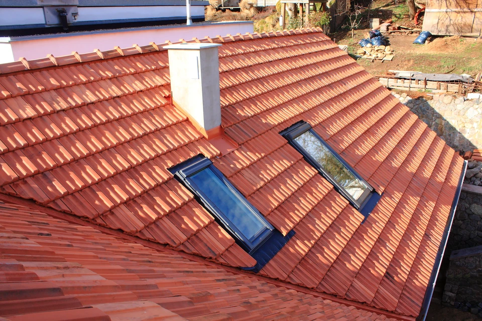 Chantier de couverture en extérieur avec toiture en tuiles terre cuite rouge-orangé