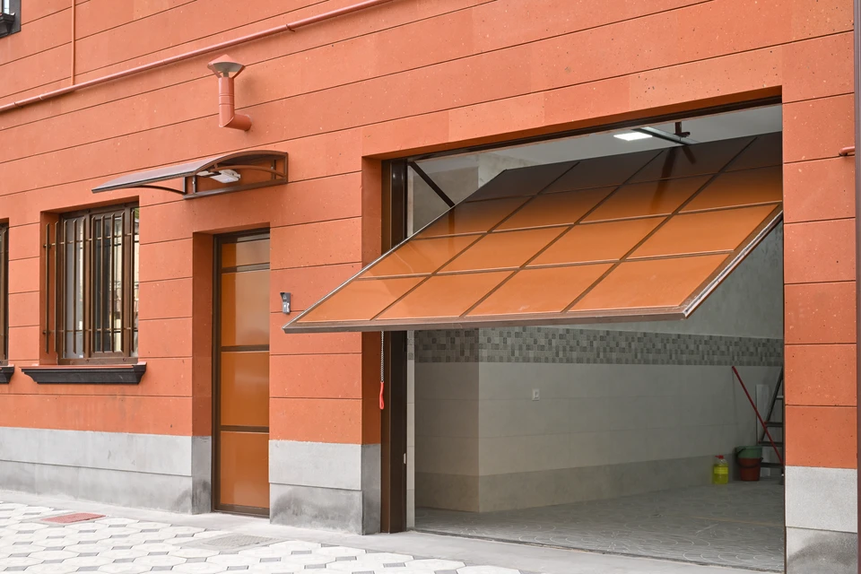 Un ouvrier installe une porte-fenêtre coulissante à châssis anthracite dans une maison en rénovation