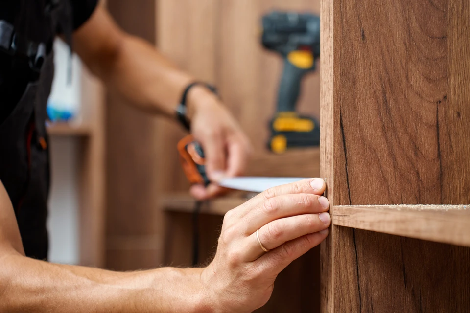Int&eacute;rieur en cours de r&eacute;novation, artisan carreleur installant du carrelage imitation bois sur chape b&eacute;ton