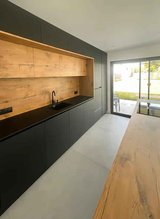 Intérieur résidentiel moderne avec couloir et trois portes en bois ouvertes donnant accès à différentes pièces : salle de bain carrelée, chambre et salon lumineux